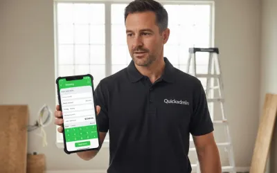 Professional contractor using the Quickadmin app on a smartphone to create an invoice at a home renovation job site.